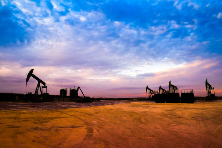 oil rigs in an oil field at sunset