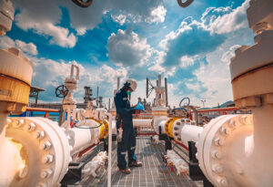 Worker performing pipe inspection and maintenance.