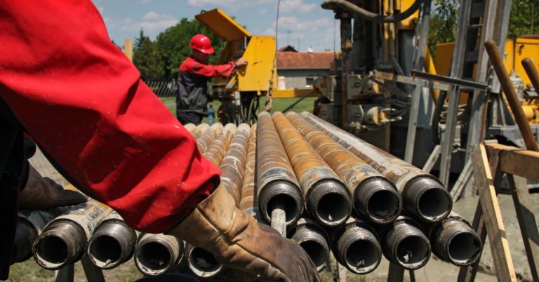 picture reveals how oil field workers handle drill pipes